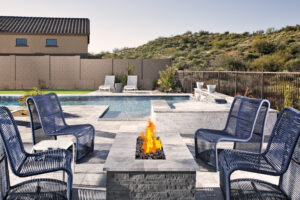 Outdoor fire pit surrounded by chairs and landscaped yard