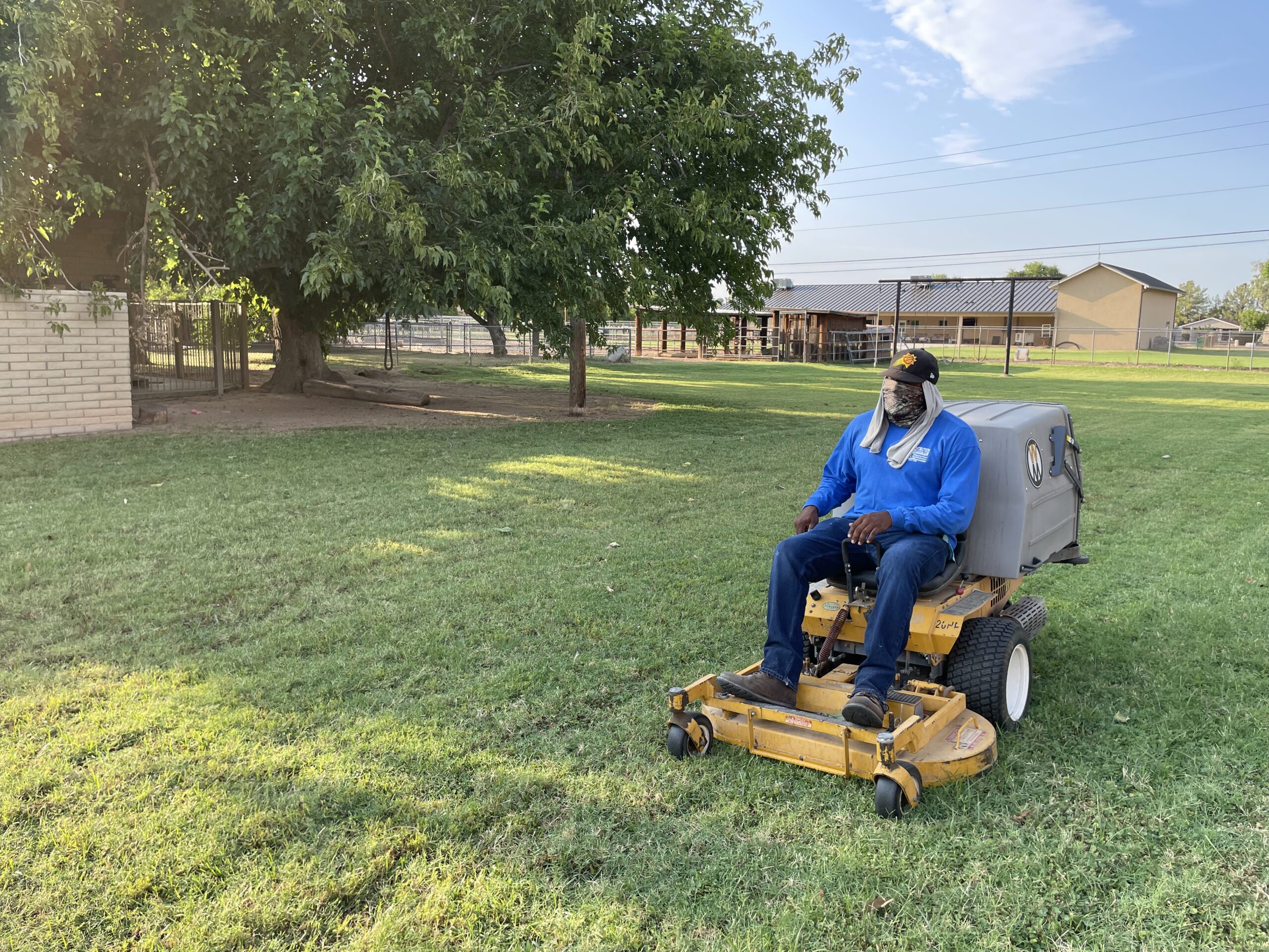 man riding lawn mower performing landscape maintenance services