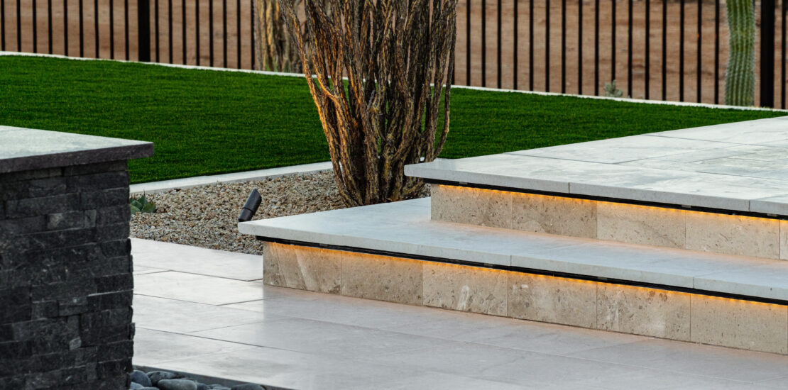 Close up image of raised sun deck, dessert bush and water feature.