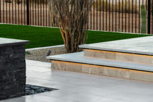 Close up image of raised sun deck, dessert bush and water feature.