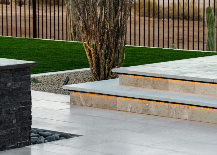 Close up image of raised sun deck, dessert bush and water feature.