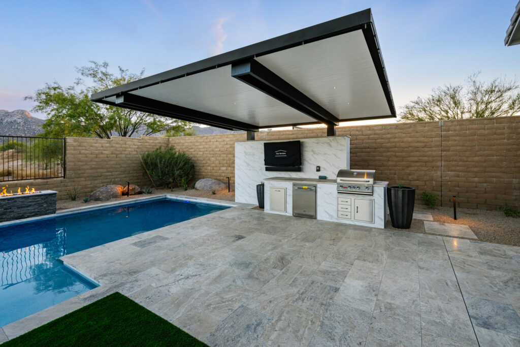 Outdoor kitchen with patio cover, pool, and pavers