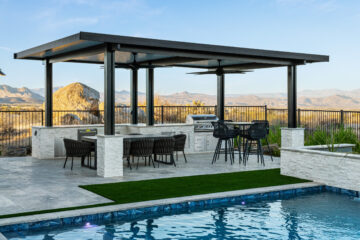 Modern outdoor kitchen and dining pavilion by Kevens Landscape featuring stainless BBQ island, bar seating, and mountain views near Phoenix, Arizona.