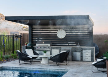 Modern Outdoor Kitchen with Pergola and Pool – Kevens Landscape AZ Alt text: Modern outdoor kitchen and BBQ area by Kevens Landscape featuring a stainless grill, pergola with misting system, and poolside seating in El Mirage, Arizona.